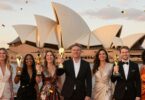 Australian business owners celebrating with trophies at sunset.