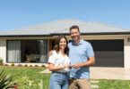 Couple holding keys outside a modern Australian home.