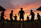 Athletes in motion, stadium sunset, trophy hint.