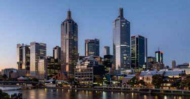 Melbourne skyline at dusk with river reflections.